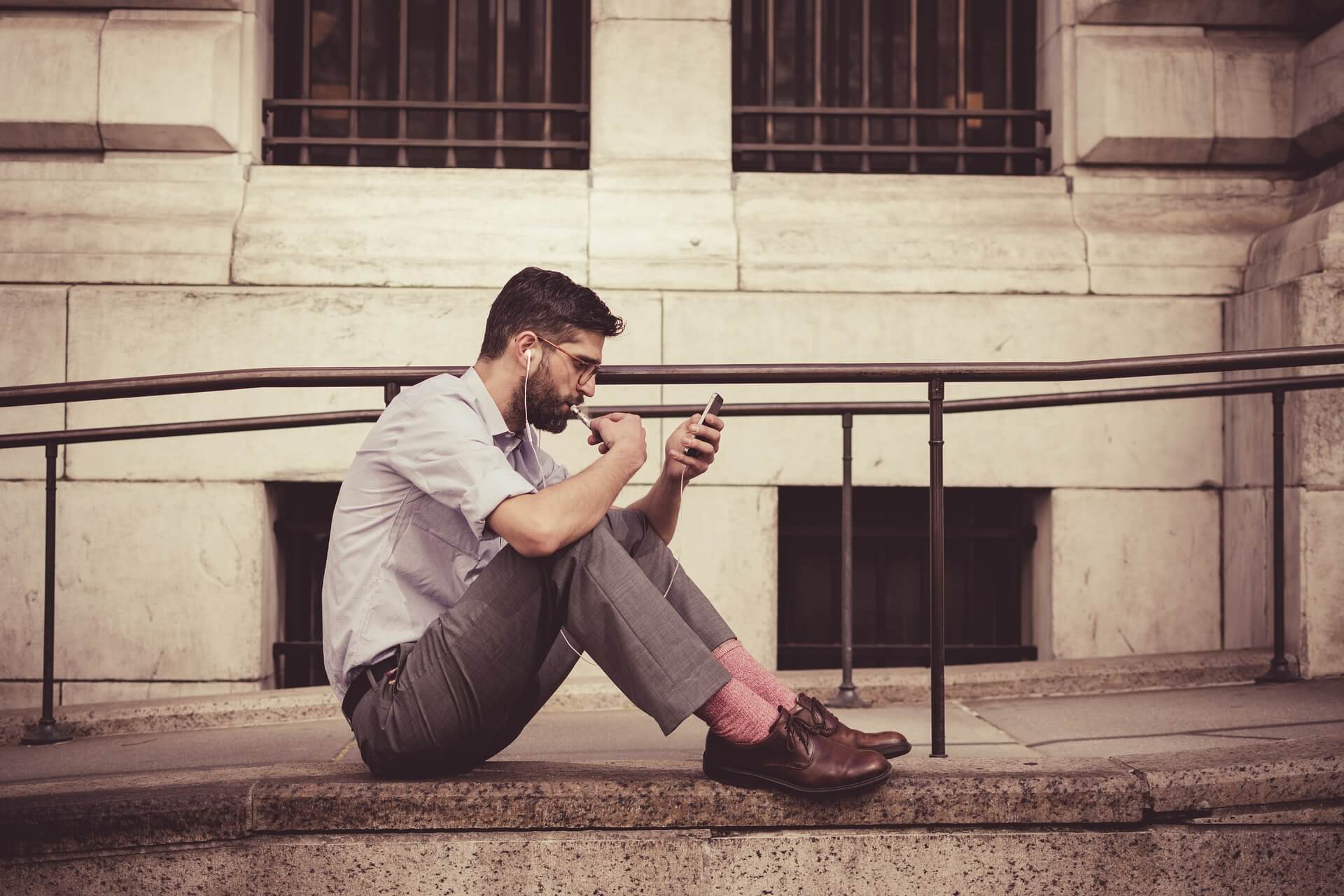 Muž sedí s mobilem v ruce a čte zprávy od milenky