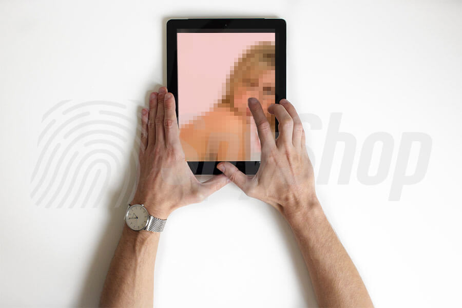 Osoba si prohlíží nahé fotky na tabletu