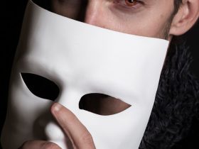 Muž zakrývá obličej maskou