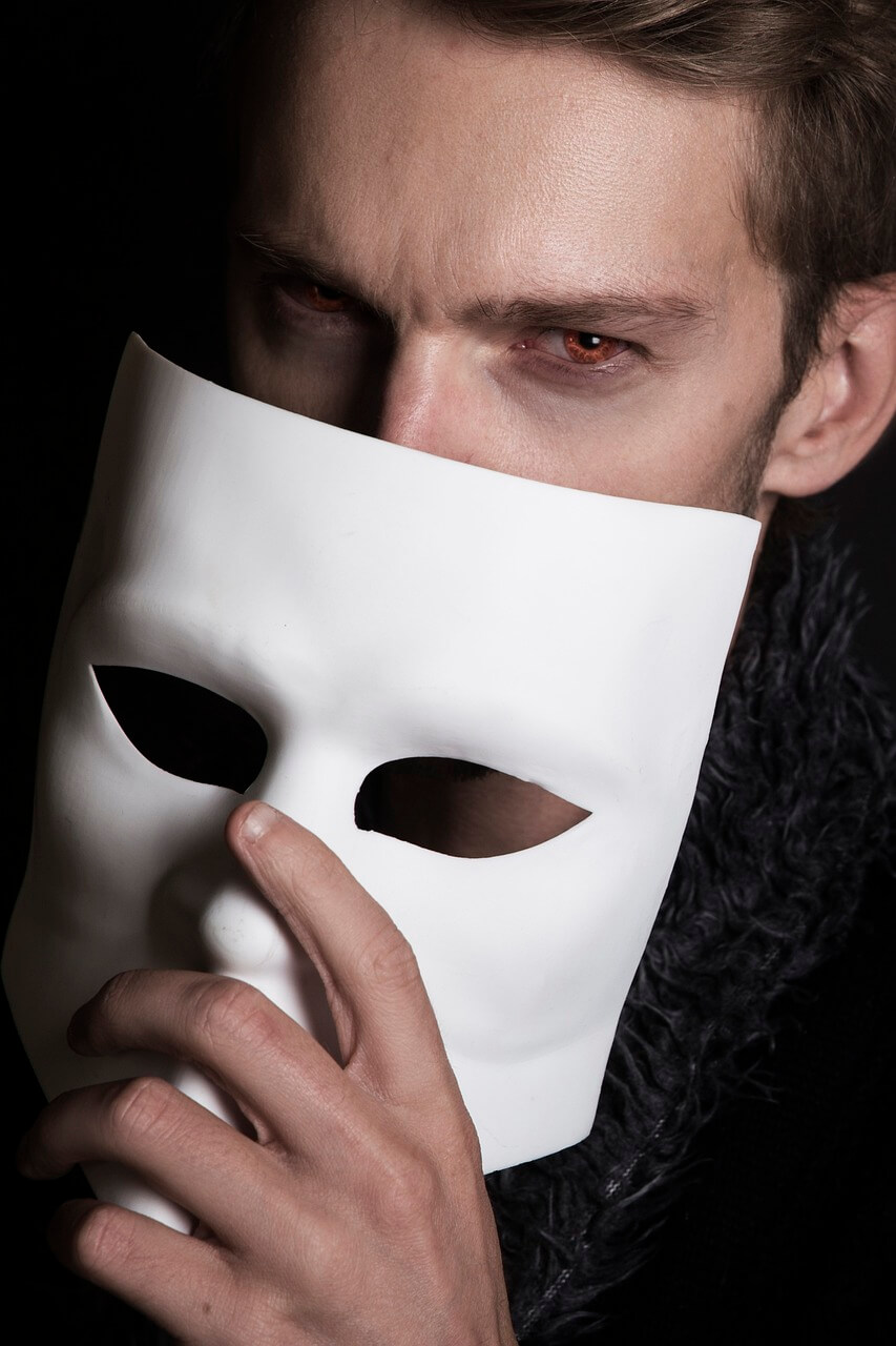 Muž zakrývá obličej maskou