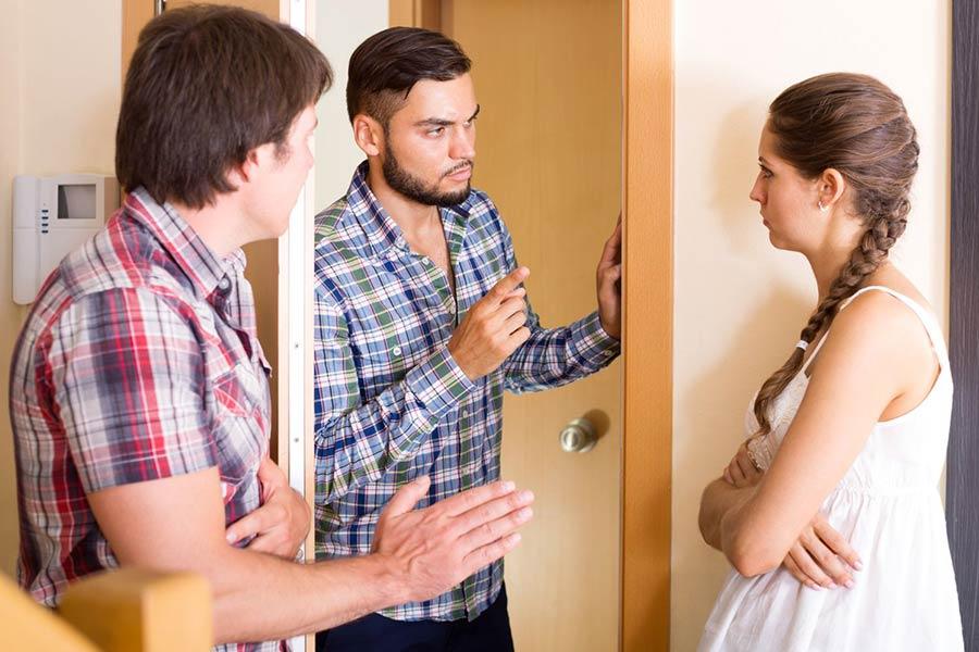 tří osoby se hádají před vchodem do bytu